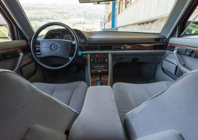 Mercedes-Benz 560 SEL - L'espace avant est séparé par une console centrale imposante.