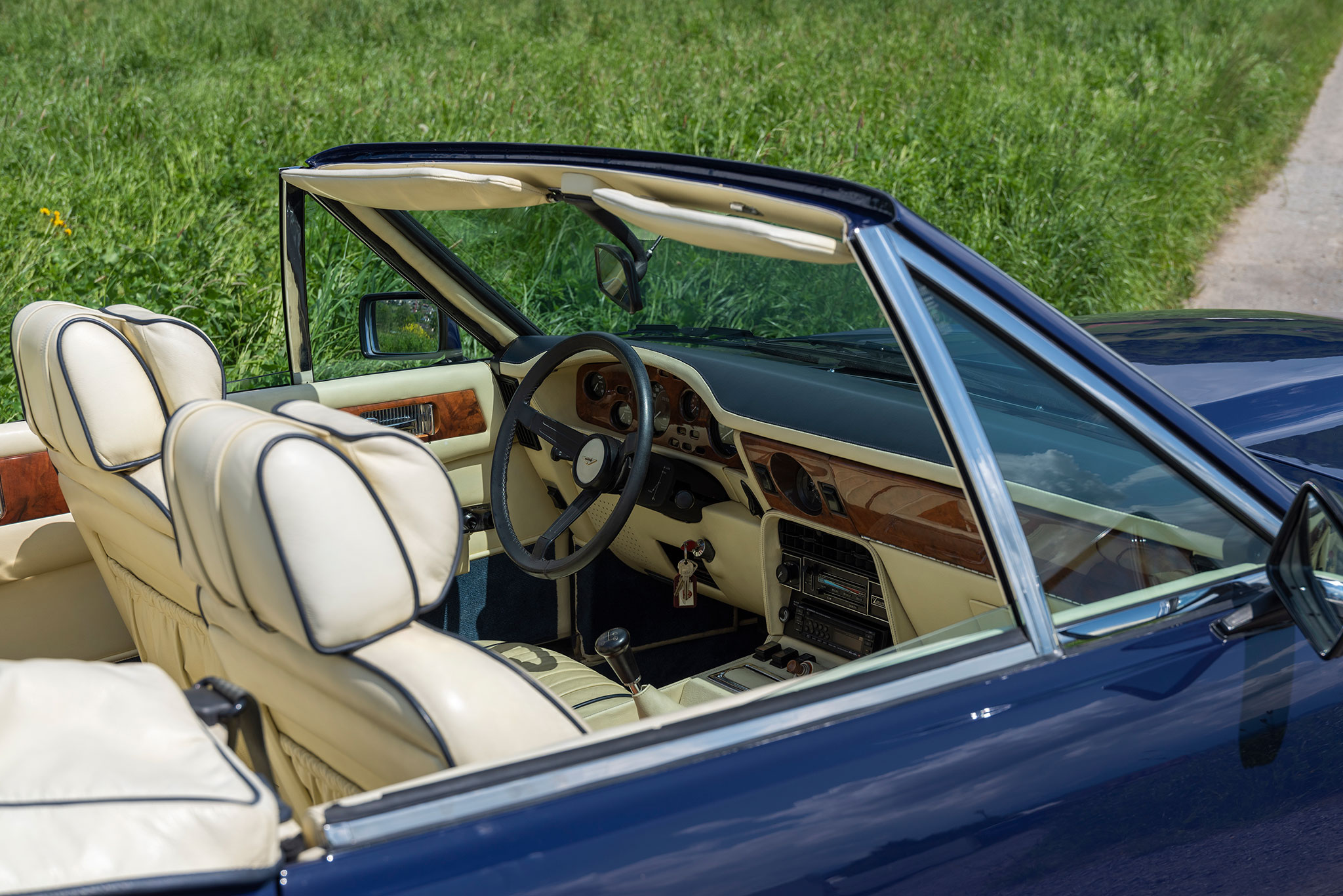 1981 Aston Martin V8 Volante Vantage Specification – bleu à l’extérieur et Magnolia rehaussé de coutures bleues, le charme anglais.