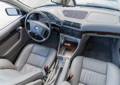 1994 BMW 540i – L’intérieur est tendu de cuir gris avec des inserts de bois sur la console et le tableau de bord.